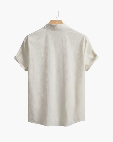 Detalhe frontal de camisa casual masculina com botões contrastantes e tecido leve.