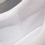 Tênis masculino com selo de grife e detalhes de luxo discreto, voltado ao público Old Money moderno.