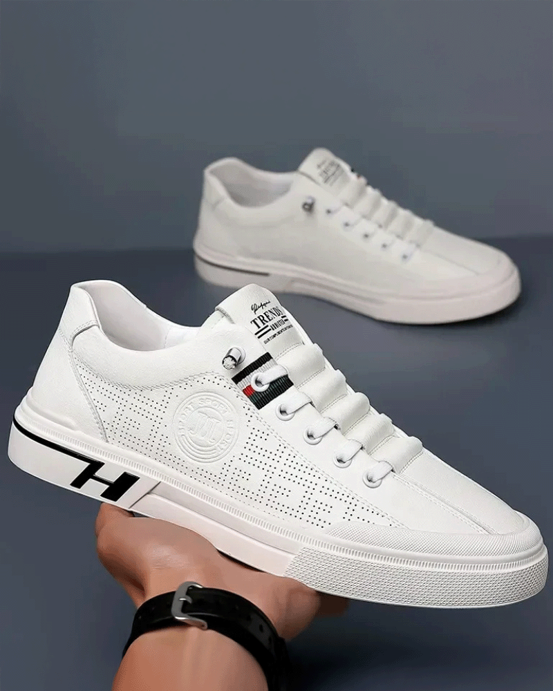 Vista superior do tênis branco de couro com cadarços simétricos e linguagem minimalista, casual e masculino.