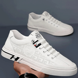 Vista superior do tênis branco de couro com cadarços simétricos e linguagem minimalista, casual e masculino.